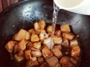 炒至均匀后加入开水，没过猪肉为佳。