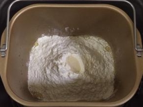 除黄油以外的面包材料都放入面包机内（先液体后粉类的顺序），在面粉中间挖个洞，把酵母粉倒入，启动和面程序。