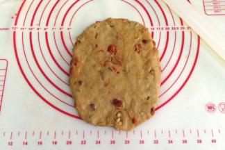 取一份松弛好的面团，用手拍扁，用擀面杖把面团擀成椭圆形。