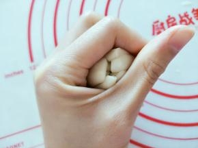 把静置好的面团擀成圆饼，包裹枣泥馅儿