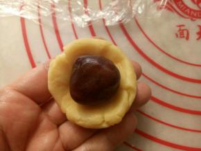 取20克的面团按扁放入一个豆沙馅包好，收口捏紧。
