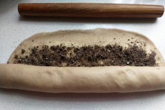 然后从底端向上卷起，收尾处用擀面杖稍微压薄再卷紧