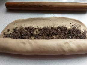 然后从底端向上卷起，收尾处用擀面杖稍微压薄再卷紧