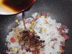 待大米煮熟，锅铲沿边缘翻开米饭，底部有锅巴。即可关火。把米饭和锅巴一起铲碎，然后调入味汁拌匀即可食用