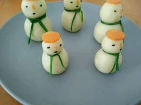 沾上芝麻做眼睛和嘴巴。剪个小小的胡萝卜做鼻子。