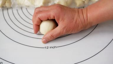 将面块用拇指与食指、中指转圈揉成圆形面团