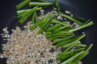 中火，热锅冷油，加入沙姜和韭菜梗，爆香