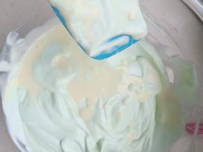 把奶油奶酪糊分三次加入淡奶油内搅拌均匀。(淡奶油是生日蛋糕剩的淡奶油，有点色素因为做蛋糕的时候打的是全发 ，我又加了一点奶油把它调成六成发的状态 就是这个颜色了，如果你家也有剩奶油也可以用这个方法把它给消耗掉 ，没有原色就好)