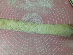 硅胶垫上撒适量糯米粉，放入糯米饭团来回搓揉，搓成长条状使江米饭完全沾满面粉