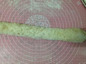 硅胶垫上撒适量糯米粉，放入糯米饭团来回搓揉，搓成长条状使江米饭完全沾满面粉