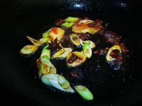 油中放入豆瓣酱葱段姜片八角炒香