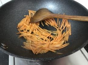锅中再添少许油，萝卜丝下锅炒至变软