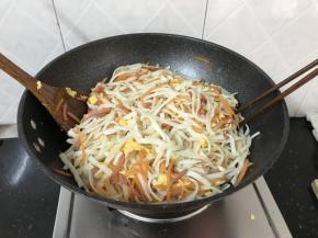 翻炒均匀，如图铲子和筷子两边往中间挑起，这样粉条不易断碎