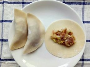 饺子皮中间放入白菜肉末再往边边涂点水然后对折起来