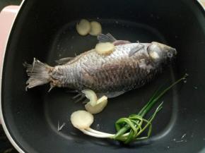 煎至两面金黄倒入少量料酒，放入葱和姜片！