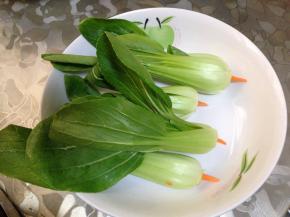 
胡萝卜削成枣核状，插入小油菜心底部