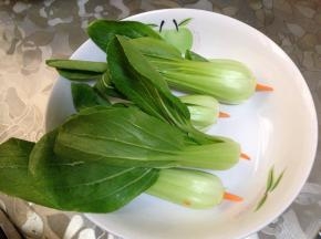 
胡萝卜削成枣核状，插入小油菜心底部