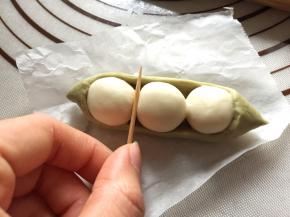 翻回正面，用竹签在“豌豆粒”的缝隙处轻压一下面皮，形成弧度。