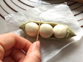翻回正面，用竹签在“豌豆粒”的缝隙处轻压一下面皮，形成弧度。