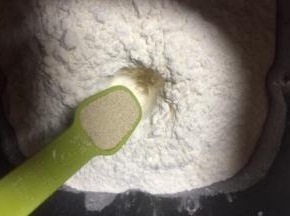 把材料除了黄油红豆沙外，，都放入面包桶，顺序为牛奶、鸡蛋、糖和盐对角放，然后放面粉，面粉挖个洞放入酵母
