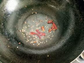 放入花椒粒和干红椒爆香