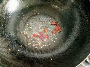 放入花椒粒和干红椒爆香