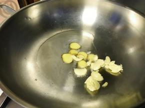 油锅烧热，爆香姜片和蒜瓣。