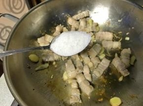 待肉煸炒至泛白，加入白糖两汤匙。