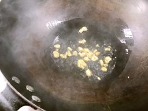 锅置火上，倒入菜籽油，放入大蒜碎爆香