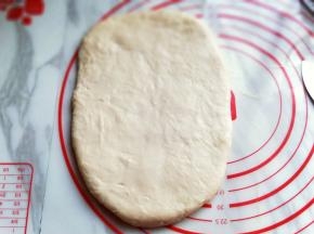 将排气好的面团用擀面杖擀长方形，约2厘米。