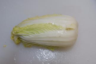 将整颗娃娃菜放入水中泡一下，洗净，甩掉水分。用刀把根部老皮削掉（不要把根部削掉切，否则娃娃菜会散开的）。