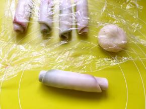 之后将面团卷起来，盖保鲜膜松弛15分钟