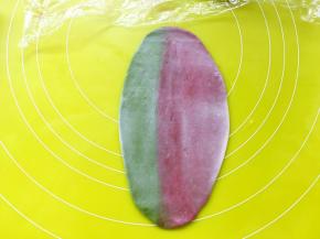 取一份松弛好的面团，顺着擀成长条，两个颜色仍然是一左一右的摆放顺序