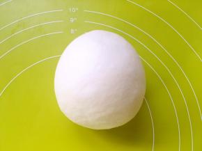 在揉面垫上，将面团一直揉至面团表面光滑，盖保鲜膜松弛