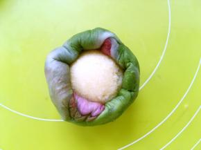 包裹上椰蓉馅，慢慢推揉面团，将收口收紧，收口朝下，整理好形状放入烤盘