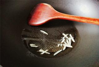 热锅冷油，放入切好蒜片炸香