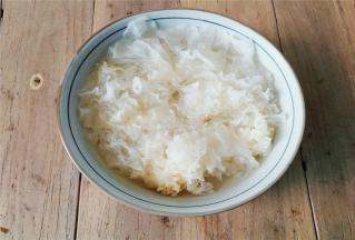 备一碗倒入清水，把银耳扳成小块泡入，充分泡发