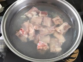 把切成段的排骨放入加了水的锅中加料酒焯下水。