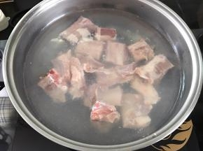把切成段的排骨放入加了水的锅中加料酒焯下水。