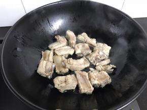 煸出香味后把花椒粒捞出。放入排骨。