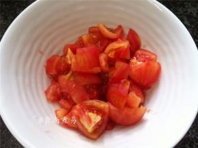 番茄洗净用刮皮刀去皮。（或是切个十字刀，用筷子插起在火炉上烤一会再轻松去皮。我喜欢前者，既方便又保存了番茄的味道。）切小块