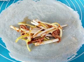 取一张春卷皮，上面放一点馅料