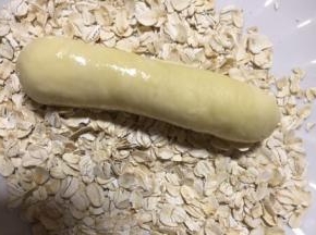 在面包胚表面沾水放在燕麦片盘里滚一圈