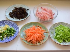 猪肉切丝，木耳泡发洗净切丝，胡萝卜和尖椒切丝，切葱姜蒜末