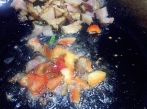 把腊肉推在锅的一遍，放入甜椒