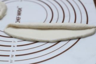 将面团分割成55克大小，揉至长舌状从一边卷起。