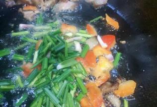 把腊肉推在锅的一遍，放入甜椒放入蒜苗稍炒匀