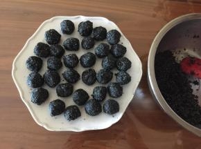 把猪油（或黄油）隔热水融化，和黑芝麻、细砂糖一起拌匀，揉成10克左右的小圆球，放入冰箱冻硬。