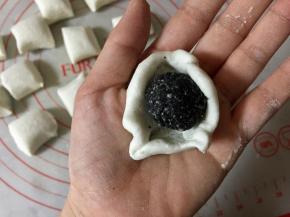 把小剂子揉圆按扁，包入冻硬的黑芝麻馅儿。