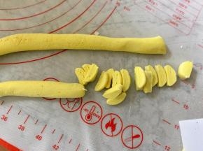 把黄色糯米团揉成细长条，切成小块。